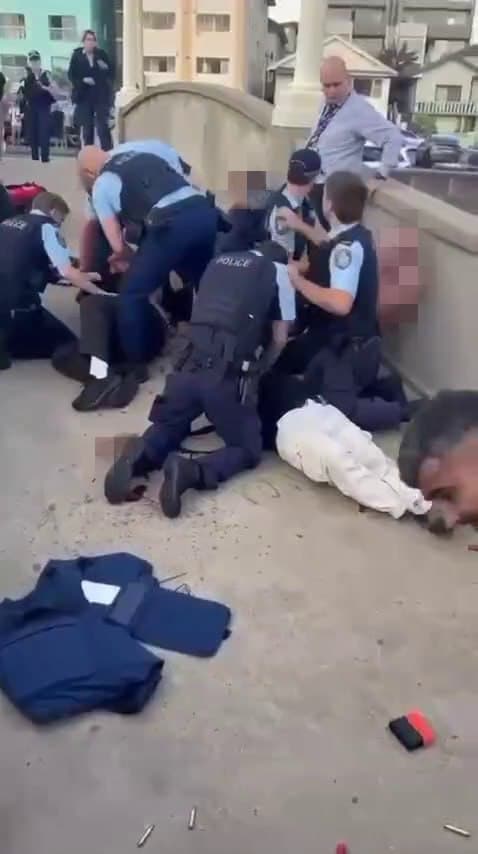 קליעים על הרצפה ומאמצי החייאה באחד המחבלים בזירה (צילום: לפי סעיף 27א' לזכויות יוצרים ) תיעוד: ירי המוני במסיבת חנוכה בסידני שבאוסטרליה