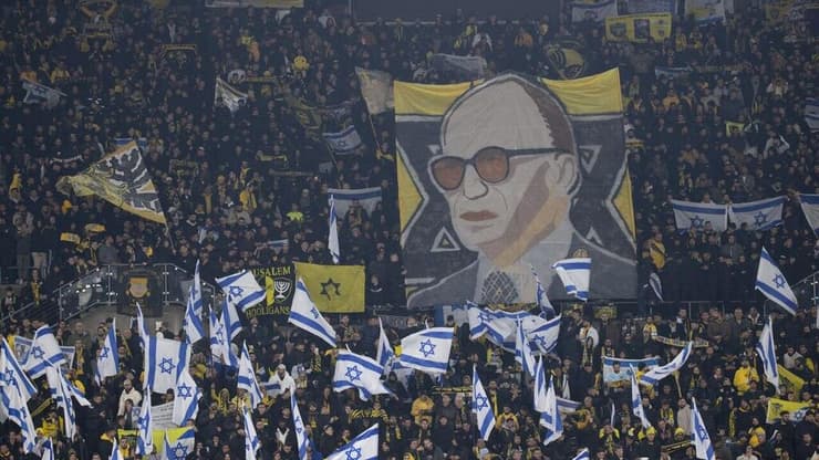 אוהדי בית"ר מניפים דגל כך לצד דיוקן של מנחם בגין (צילום: אלכס קולומויסקי) אוהדי בית"ר