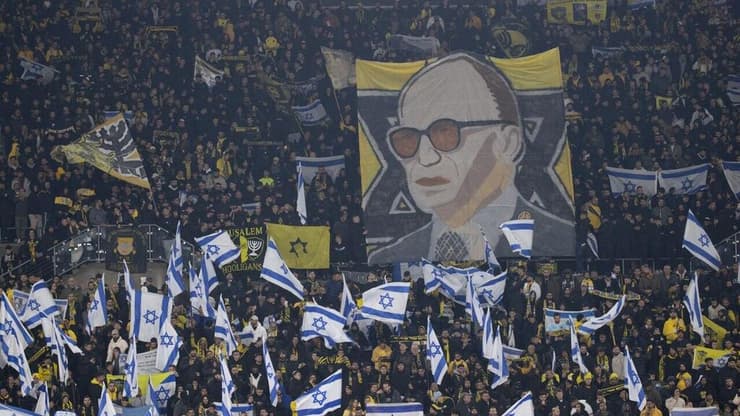 אוהדי בית"ר מניפים דגל כך לצד דיוקן של מנחם בגין (צילום: אלכס קולומויסקי) אוהדי בית"ר