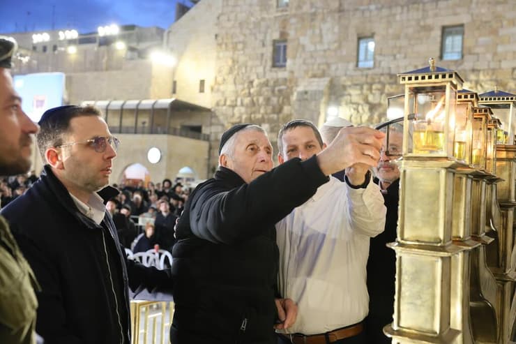 אביו של בנימין מדליק נרות חנוכה בכותל המערבי