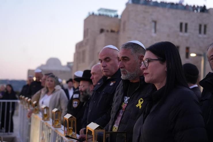 "לא עוברים לשלב השני עד שרני חוזר". ההורים איציק וטלי בכותל (צילום: דוברות המשטרה) משפחת גואילי מדליקה חנוכיה בכותל המערבי