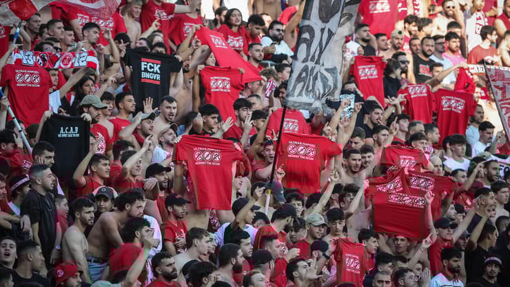 אוהדי הפועל ת"א עם חולצות המחאה נגד המשטרה, בשבת (צילום: עוז מועלם) אוהדי הפועל ת"א חולצה משטרה