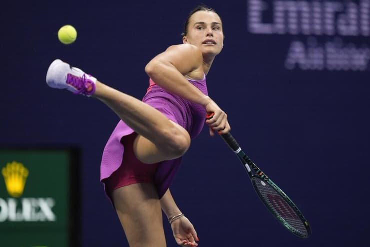 דריבל מרשים. הטניסאית מספר 1 בעולם, ארינה סבאלנקה, מפגינה כישורים ממגרש אחר (צילום: AP Photo/Julia Nikhinson) דריבל מרשים. הטניסאית מספר 1 בעולם, ארינה סבאלנקה, מפגינה כישורים ממגרש אחר