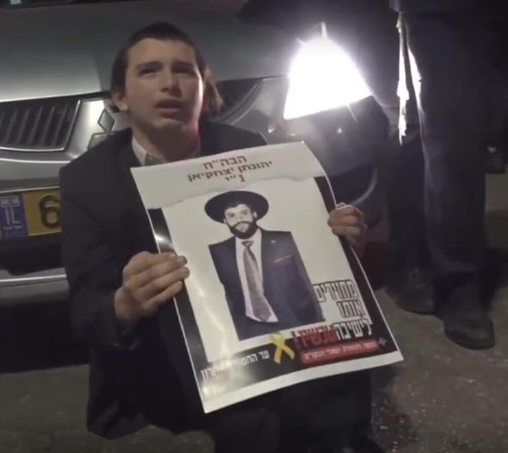 עריק מוצג כחטוף בשלט בהפגנה