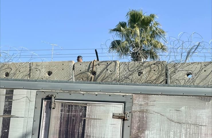 שב"ח מציץ מבעד לגדר רגע לפני הכניסה לירושלים