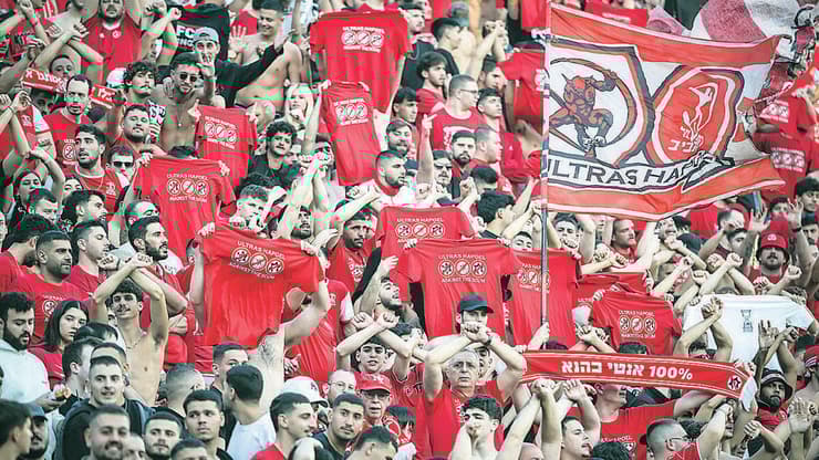 אוהדי הפועל תל אביב מניפים את חולצות המחאה נגד המשטרה