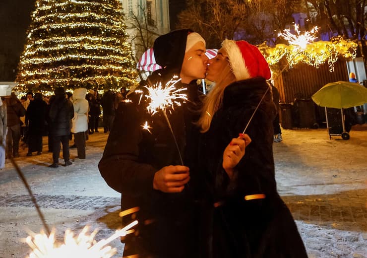 בקייב התנשקו לציון השנה החדשה עוד לפני חצות, על רקע עוצר שהוטל שם בליל הסילבסטר מחשש למתקפה רוסית (צילום: REUTERS/Gleb Garanich) קייב אוקראינה לקראת חגיגות שנה חדשה 2026 ולפני עוצר שייכנס שם לתוקף בצל מלחמה מול רוסיה