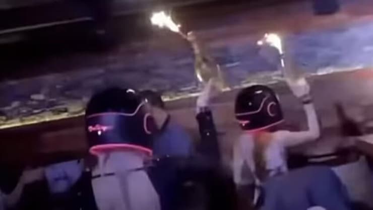 אסון שריפה בר עיירת סקי שווייץ מתוך סרטון קידום של הבר שבו מלצריות צועדות עם בקבוקי שמפניה שבתוכם זיקוק