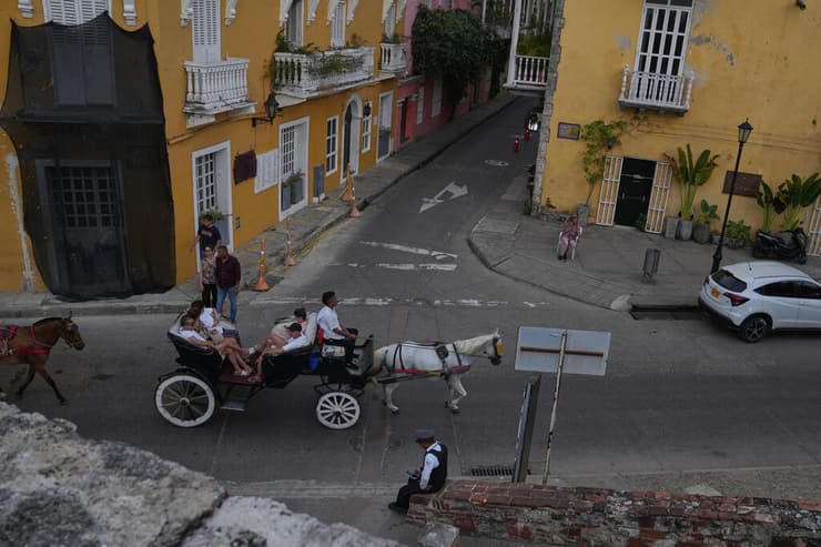תיירים רכובים על כרכרות סוסים מסורתיות במרכז העיר קרטחנה