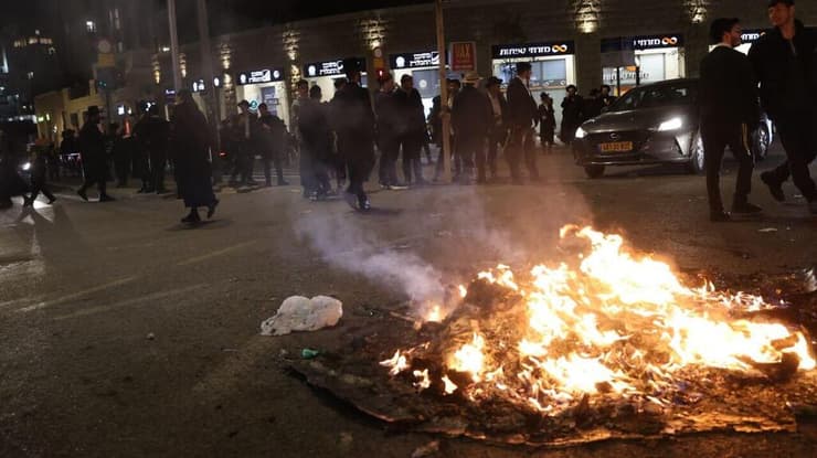 מדורות הובערו על הכביש (צילום: אלכס קולומויסקי) זירת דריסת המפגין החרדי בירושלים