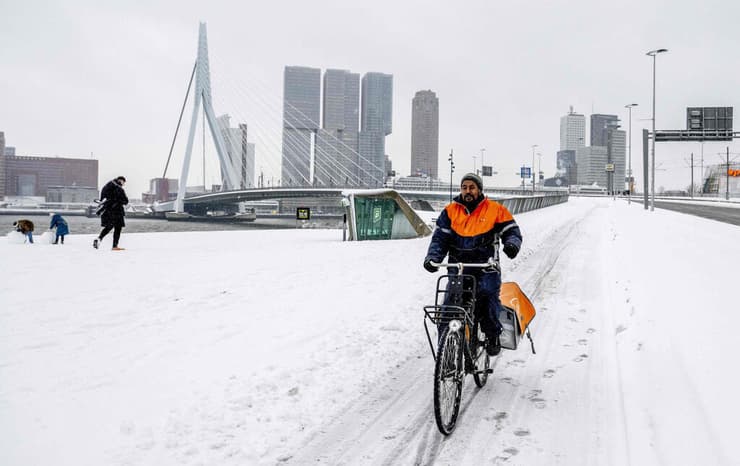 אירופה מזג אוויר גל קור הולנד רוטרדם דוור על אופניים