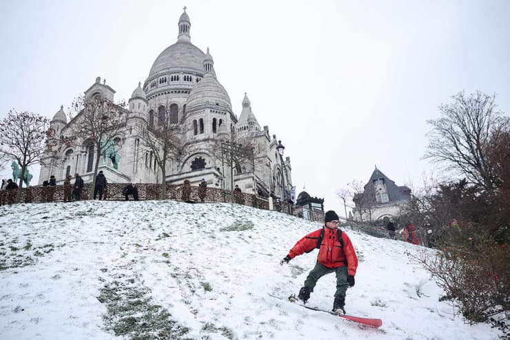 אירופה מזג אוויר גל קור צרפת גולש סנובורד בגני כיכר לואיז מישל בשכונת מונמארטר ב פריז