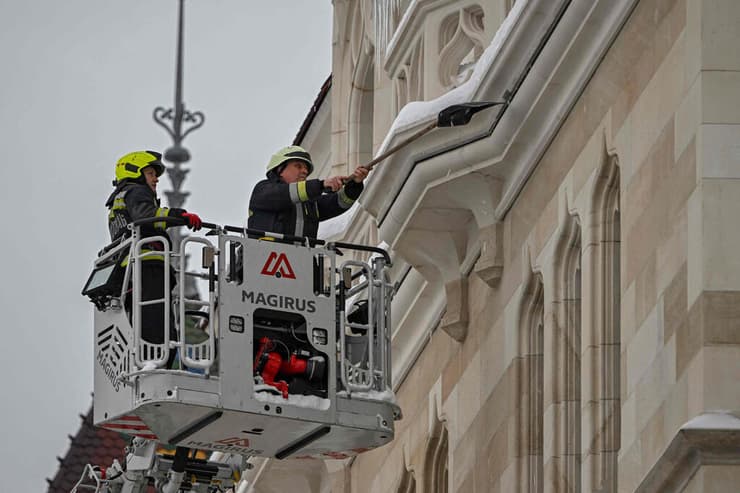 אירופה גל קור מזג אוויר דגל הונגריה כוחות הצלה מסלקים שלג מ בניינים ב בודפשט