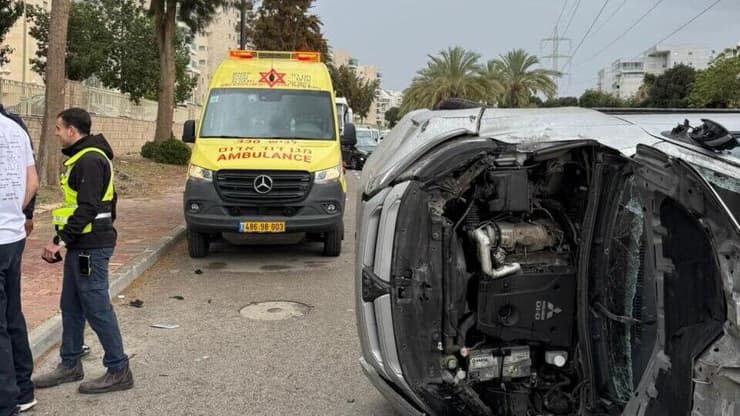הרכב שהתהפך מאשקלון (צילום: דוברות מד"א) רכב שהתהפך לאחר שנפגע מעץ שקרס שדרות יצחק רבין באשקלון