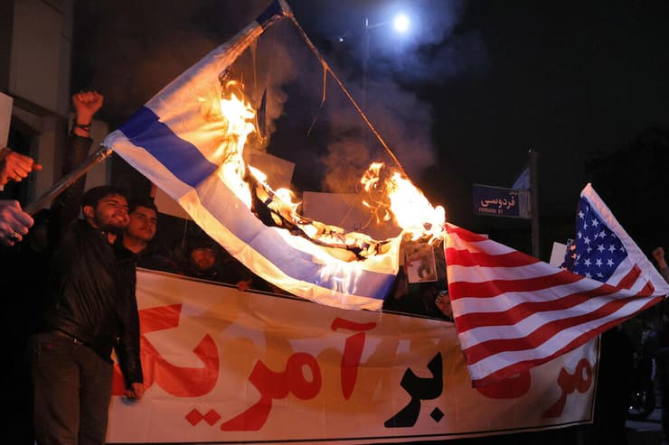 טהרן איראן אנשי מיליציה בסיג' הנאמנים למשטר שורפים דגלים של ישראל ו ארה"ב מול שגרירות בריטניה