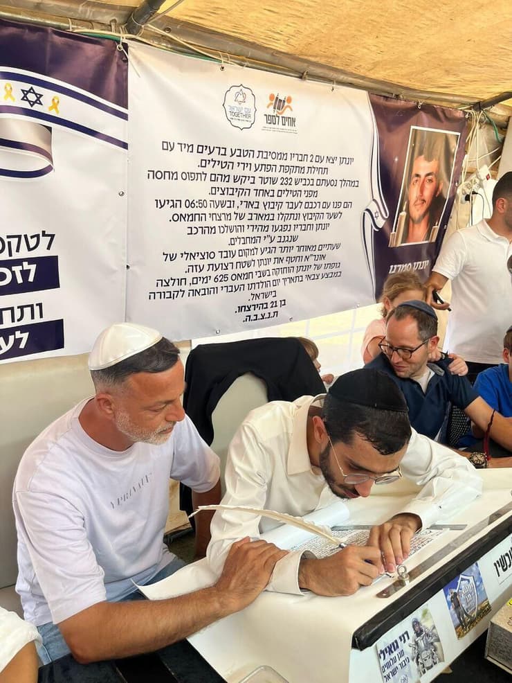 קובי סמרנו (משמאל) במעמד כתיבת אות בספר התורה לזכר בנו, יונתן ז"ל
