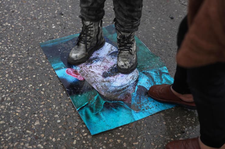 סוריה א-טבקה תומכי משטר א-שרע דורכים על דיוקנו של המנהיג הכורדי הכלוא (בטורקיה) עבדאללה אוצ'לאן אחרי נסיגת כוחות כורדים SDF מהעיר