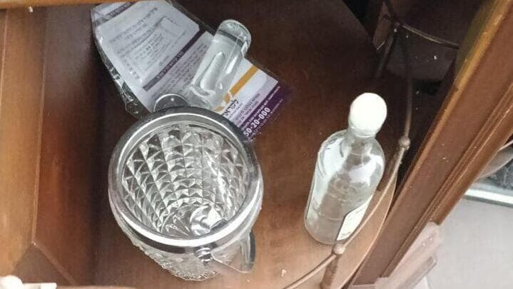 בקבוק אלכוהול שהושאר בדירה על ידי הפורצים (צילום: באדיבות הדיירים) ונדליזם בבניין דירות בפתח תקווה שנפגע מטיל איראני