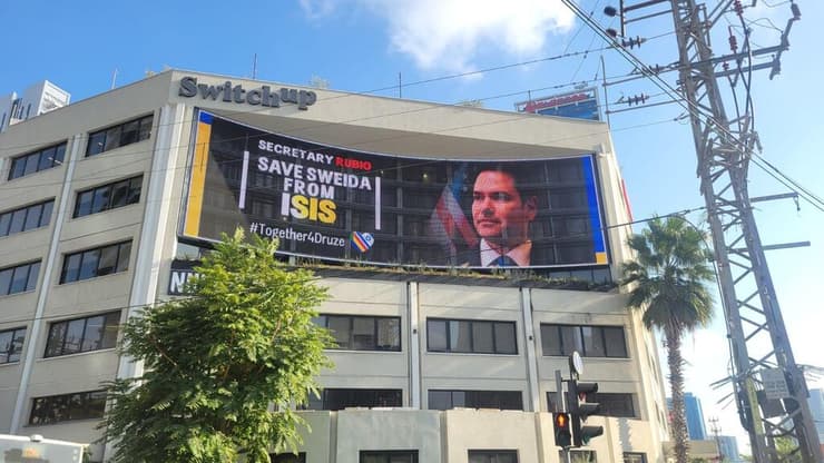 שלט חוצות עם קריאה להתערבות מזכיר המדינה האמריקאי, מרקו רוביו, בטבח בא-סווידא 