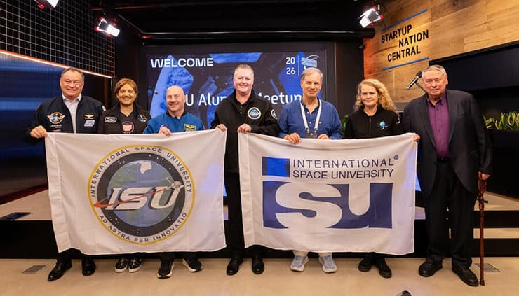 צעדים לבניית הדור הבא של תעשיית החלל הישראלית. סטיבה (שלישי מימין) וג'ון ונסווין (רביעי מימין), עם דגלי אוניברסיטת החלל, ועם המדען פיט וורדן (Worden) (מימין), והאסטרונאוטים (מימין לשמאל) ג'ולי פאייט (Payette), גארט רייזמן (Reisman), סיאן פרוקטור (Proctor) ומייקל לופז אלגריה (López-Alegría), שהשתתפו באירועי שבוע החלל הישראלי 