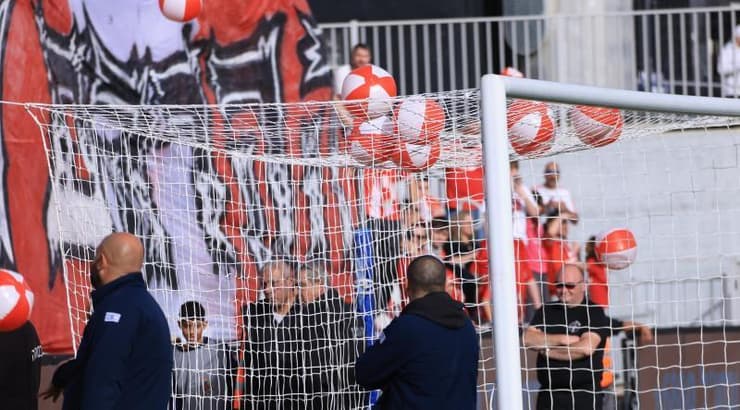 אוהדי הפועל תל אביב משליכים כדורים למגרש