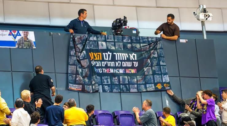 אוהדי הפועל חולון מורידים את שלט החטופים