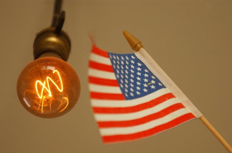 נורת החשמל שדולקת כבר 125 שנים, לצד דגל ארצות הברית