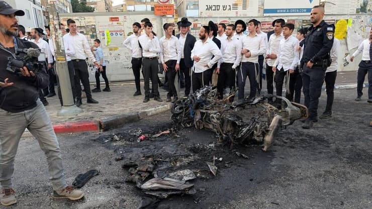 האופנוע המשטרתי שהוצת בבני ברק (צילום: Nicholas Pfosi) שריפת אופנוע משטרתי בהפגנת חרדים נגד הגיוס בבני ברק