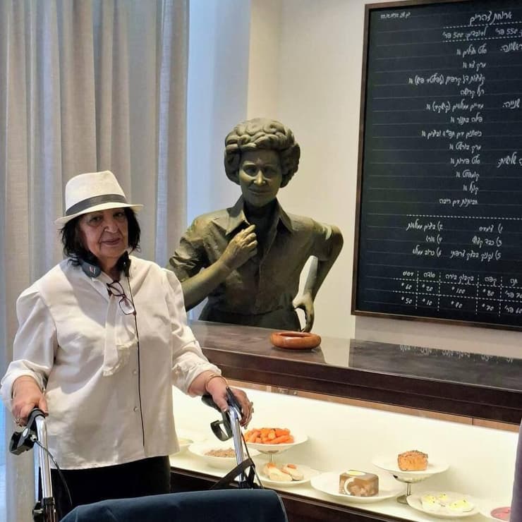 אתי אברהמי לצד פסלה של ברטה אחותה, במוזיאון הכנסת בירושלים 