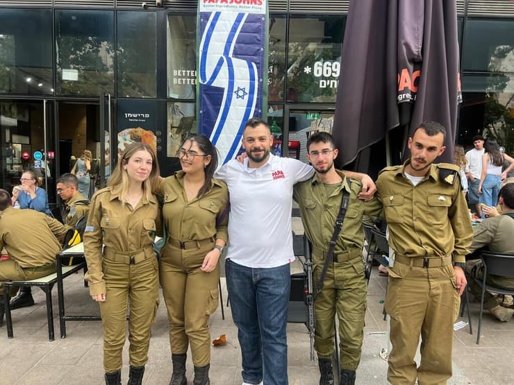 נתנאל כהן עם בני הנוער שעבדו אצלו, התגייסו וחזרו לביקור עם המדים