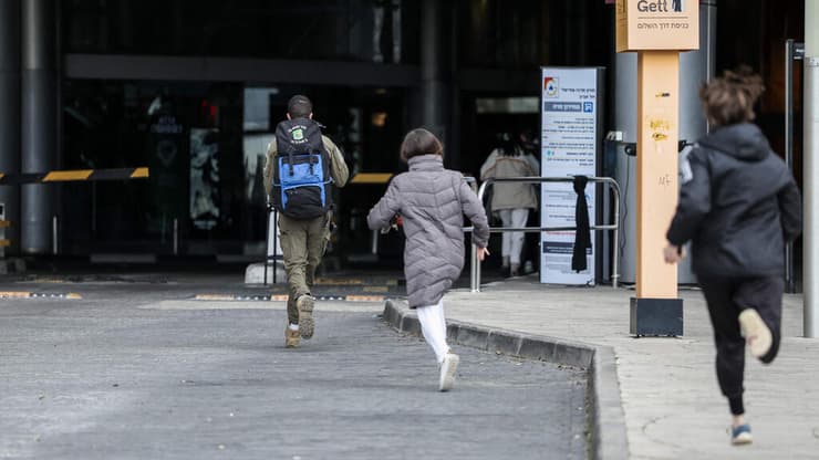 רצים למקלט בשעת אזעקה בימי "שאגת הארי" (צילום: Ilia YEFIMOVICH / AFP) תל אביב
