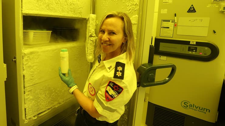 ד"ר שרון ברנסבורג-צברי, מנהלת הבנק, עם ה"גביע הקדוש" - בקבוק חלב אם שמוחזק בהקפאה עמוקה (צילום: שאול גולן) בנק החלב