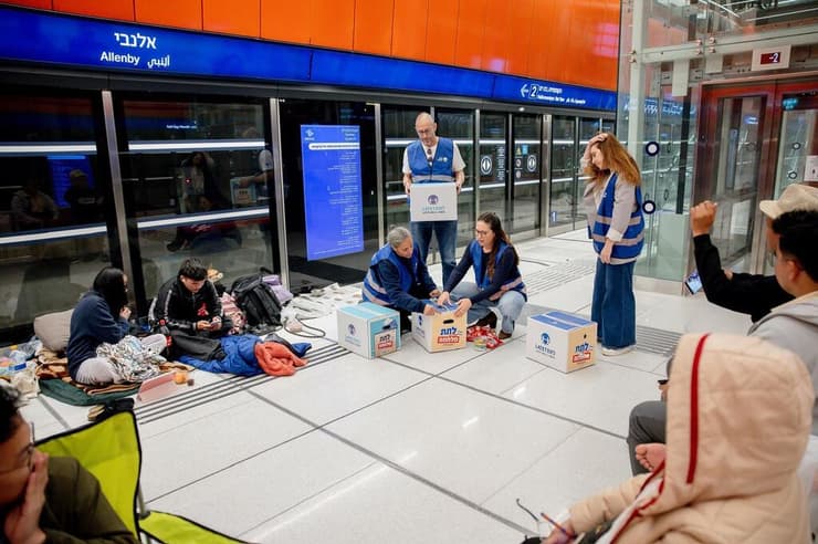 מתנדבי ארגון "לתת" מחלקים ציוד הומוניטרי לשוהים ברכבת הקלה במהלך מבצע "שאגת הארי" (צילום: מאור בן חיים) מתנדבי ארגון "לתת" מחלקים ציוד הומוניטרי לשוהים ברכבת הקלה במהלך המלחמה