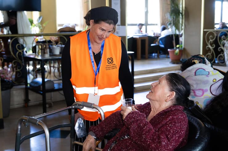 נציגת משרד הרווחה מסייעת למפונה (צילום: אלכס קולומויסקי) מפונים במלון רמדה בירושלים