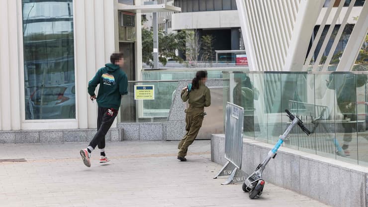 רצים לתפוס מחסה בתחנת הרכבת הקלה בשעת אזעקה בתל אביב במהלך ימי שאגת הארי