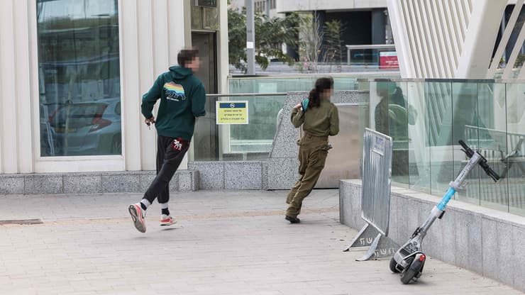 רצים לתפוס מחסה בתחנת הרכבת הקלה בשעת אזעקה בתל אביב במהלך ימי שאגת הארי