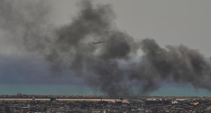 מטוס ממריא, כשברקע עשן מהדאחייה