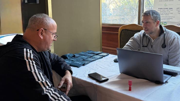 ד״ר ליפשיץ מטפל בירון, שפונה מביתו שנפגע. רפואה אישית גם מחוץ לקירות המרפאה (צילום: דוברות כללית מחוז ירושלים) ד״ר ליפשיץ מטפל בירון, שפונה מביתו שנפגע. רפואה אישית גם מחוץ לקירות המרפאה