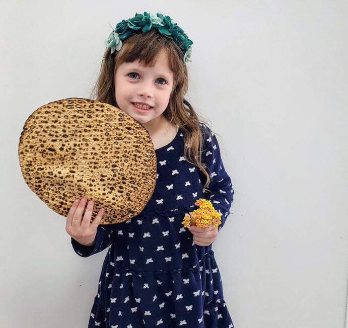 סופי המתוקה כבר מוכנה לחג הפסח עם מצה שמורה בעבודת־יד וזר פרחים אביבי שקטפה לבד בגינה