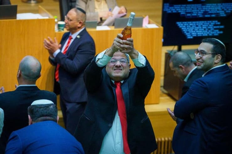 איתמר בן גביר במליאת הכנסת לאחר ההכרזה על אישור חוק עונש מוות למחבלים עם שמפניה בידו