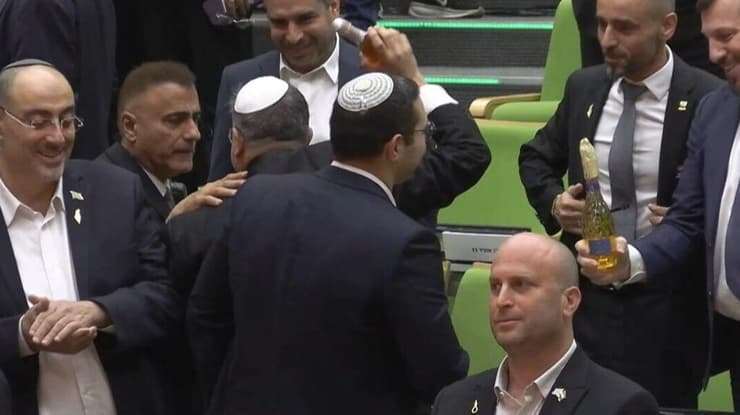 איתמר בן גביר במליאת הכנסת לאחר ההכרזה על אישור חוק עונש מוות למחבלים עם שמפניה בידו