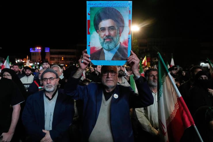 תומכי המשטר האיראני מניפים את תמונתו של מוג'תבא חמינאי לאחר ההודעה על הפסקת האש