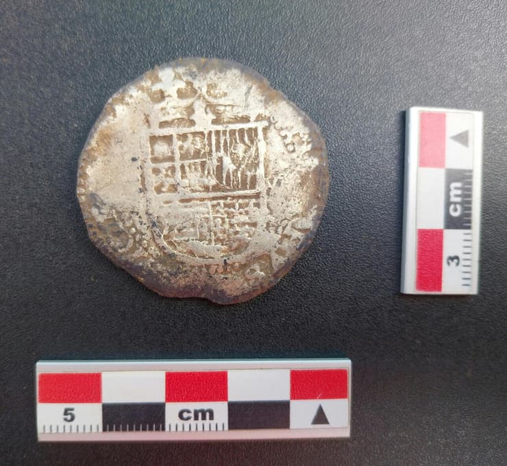 סמל המלוכה הספרדי על מטבע הכסף שהתגלה באתר סיודאד דל ריי דון פליפה בצ'ילה (צילום: Richard Bezzaza) סמל המלוכה הספרדי על מטבע הכסף שהתגלה באתר סיודאד דל ריי דון פליפה בצ'ילה