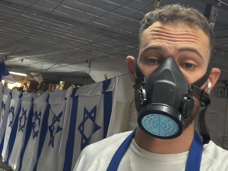 נדב ברמן בשעת צביעת הדגלים