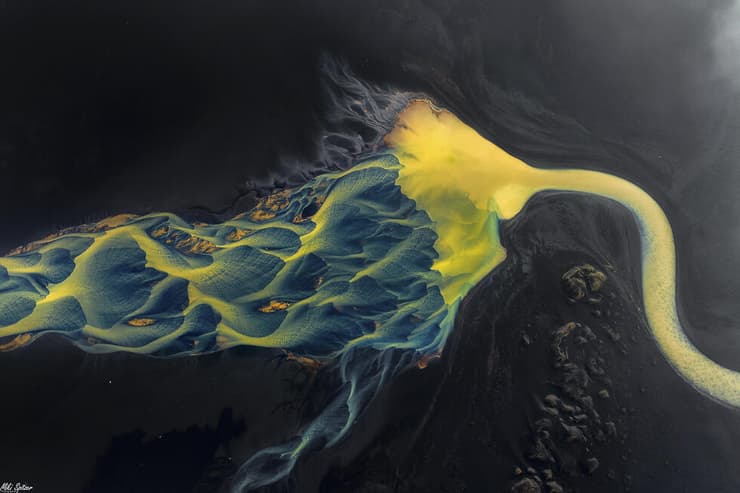 תמונת רחפן של נחל נשפך אל הים באיסלנד