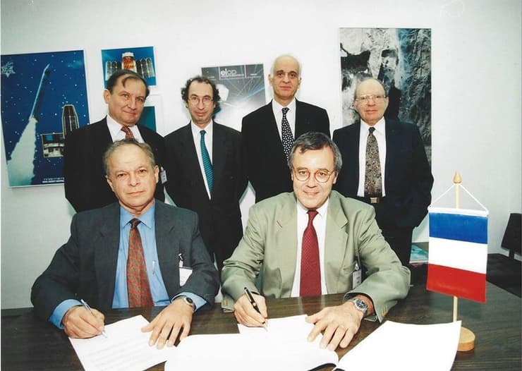 קסם אישי שהוביל לשיתופי פעולה בינלאומיים רבים. הר-אבן (יושב משמאל) חותם עם ראש סוכנות החלל של צרפת, אלן בנסוסן (Bensoussan) על ההסכם שהוביל לשיגור הלוויין המשותף ונוס
