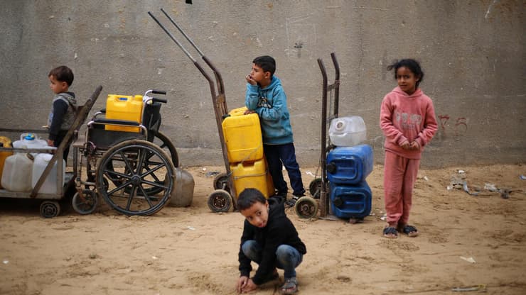ילדים מחכים בתור למילוי מכלי מי שתייה במחנה הפליטים נוסיראת במרכז רצועת עזה