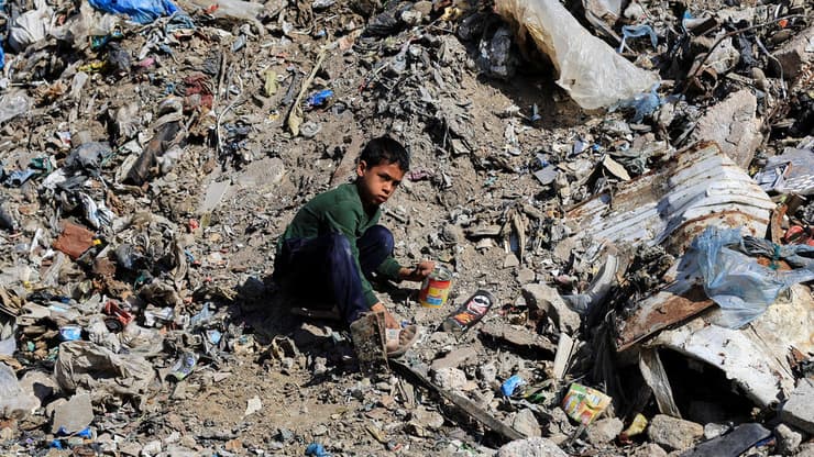 ילד פלסטיני יושב על ערימת הריסות ואשפה ברצועת עזה