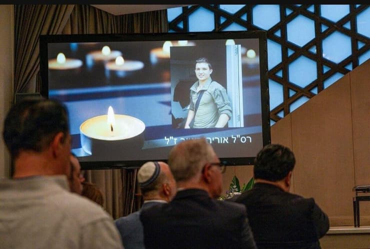 רחל באייר מציגה את תמונת אחיה אוריה ז"ל בהרצאה בברלין