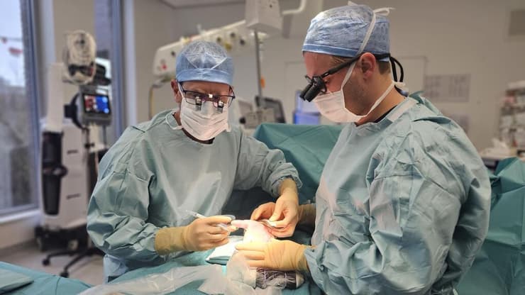 ד"ר בירן וד"ר מיכיל קרומהקה מבצעים ניתוח לתסמונת התעלה הקרפלית בגישה החדשה (צילום: Michiel Cromheecke) ניתוח לתסמונת התעלה הקרפלית, בית החולים AZ Maria Middelares, בלגיה